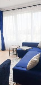 salon z 2 niebieskimi łóżkami i stołem w obiekcie Fairytales Apartment we Wrocławiu
