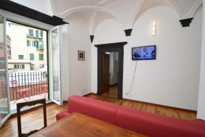 ein Wohnzimmer mit einem roten Sofa und einem Balkon in der Unterkunft Soana Apartment in Genua
