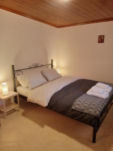 a bedroom with a large bed with a wooden ceiling at Τείχιο Μπουτίκ - Tihio Boutique - Πέτρινος ξενώνας in Tíkhion