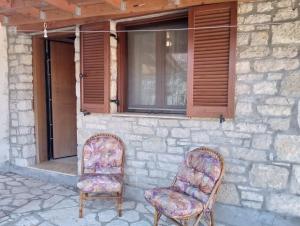 two chairs sitting in front of a building at Τείχιο Μπουτίκ - Tihio Boutique - Πέτρινος ξενώνας in Tíkhion