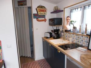 a kitchen with a counter with a sink and a woman in the mirror at Les deux moulins in Saint-Alban