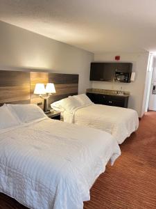 Landmark Resort في ميرتل بيتش: سريرين في غرفة الفندق ذات شراشف بيضاء