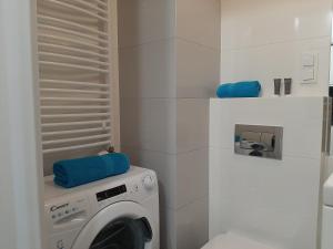 a white washing machine in a white bathroom at Apartament Pianista in Warsaw