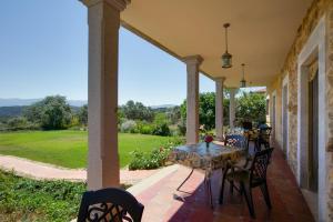 eine Terrasse mit Tisch und Stühlen auf einer Veranda in der Unterkunft Apartamentos El Jardín del Poeta in Guijo de Granadilla
