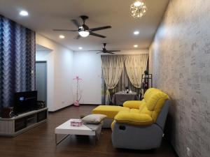 a living room with a yellow couch and a tv at Sweet Home Silk Sky Residence Balakong Seri Kembangan in Seri Kembangan