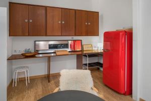 een keuken met een rode koelkast en houten kasten bij Le Loft Roquelaine in Toulouse