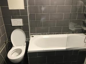 a bathroom with a toilet and a bath tub at Arcotel Cannes 4 minutes du Palais des Festivals - NEW MANAGEMENT NEW TEAM - OLD REVIEVV in Cannes