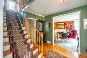 una escalera en una casa con paredes verdes y un comedor en Abacot Hall Bed & Breakfast en Niagara on the Lake