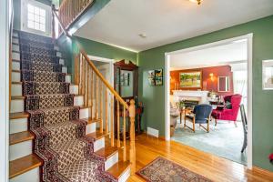 a staircase in a home with green walls and a dining room at Abacot Hall Bed & Breakfast in Niagara on the Lake