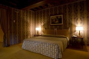 ein Schlafzimmer mit einem Bett und zwei Lampen an zwei Tischen in der Unterkunft Hotel Villa La Principessa in Lucca