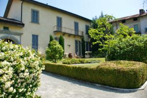 Villa Casati Italiana في Casatenovo: منزل تحوط أمام مبنى