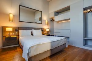 a bedroom with a large bed and a mirror at 8 Building Serviced Apartment by the River in Lisbon