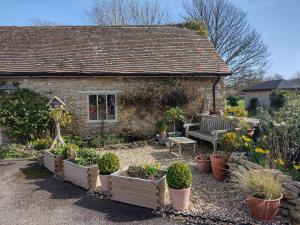 a garden in front of a house with potted plants at Long Barn in Burton Bradstock