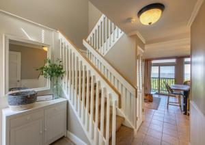 a white staircase in a home with a view of the ocean at Villas by the Sea Resort & Conference Center in Jekyll Island