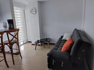 a living room with a black couch and a table at Buena Vista Suites in Armenia