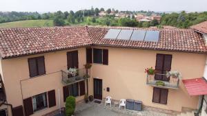 Casa Graziella- appartamenti vacanze في Portacomaro: منزل على السطح مع لوحات شمسية