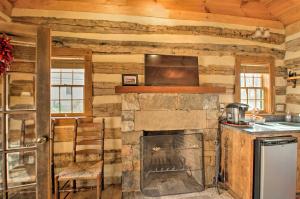 - une cuisine avec une cheminée en pierre dans une cabane en rondins dans l'établissement Lovely Wooded Cabin with Numerous Trails On-Site!, à Earlysville