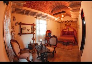 a room with a bedroom and a bed and chairs at Hotel Posada de la Conspiración in Dolores Hidalgo +31 photos