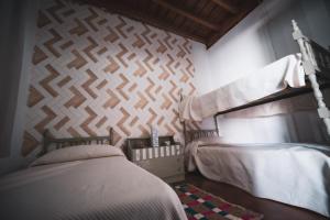 a bedroom with two beds and a wall at Alojamiento rural antigua fragua in El Real de la Jara
