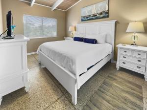 a bedroom with a large white bed and a television at Cool Breeze Home in Inlet Beach