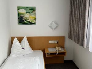 Habitación de hotel con cama y teléfono en Hotel-Pension Sternen en Klaus