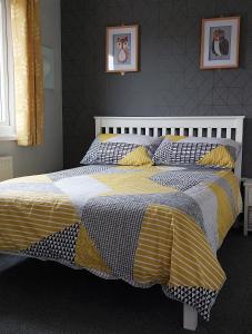 um quarto com uma cama com um edredão amarelo e branco em 89 Lower Lakeside - Glan Gwna Holiday Park em Caernarfon