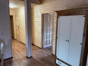 Habitación vacía con paredes de madera y puertas blancas. en Restauracja i Noclegi Izba Rybacka w Krainie Wygasłych Wulkanów en Podgórki