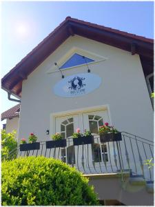 ein weißes Gebäude mit Topfpflanzen auf einem Balkon in der Unterkunft Pension Miss Sophie in Kyritz