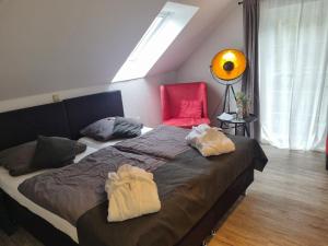 ein Schlafzimmer mit einem großen Bett und einem roten Stuhl in der Unterkunft Pension Miss Sophie in Kyritz