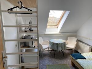 um quarto com uma escada, uma mesa e cadeiras em Bigus em Berlim