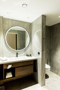 a bathroom with a sink and a mirror at Hotel Am Schloss Aurich - Schlossresidenz in Aurich