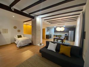 un salon avec un canapé et un lit dans l'établissement Apartamentos La Xerea, à Valence