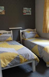 two beds sitting next to each other in a room at 89 Lower Lakeside - Glan Gwna Holiday Park in Caernarfon