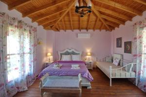 a bedroom with a purple bed and a wooden ceiling at ORFEAS HOUSE 2 in Patitiri