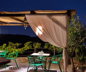 a table and chairs on a patio at night at ORFEAS HOUSE 2 in Patitiri +10 photos