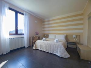 a bedroom with a bed with a striped wall at Agriturismo La Pietra in La Spezia