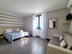 ラ・スペツィアにあるAgriturismo La Pietraのベッドルーム(ベッド1台、ソファ、鏡付)