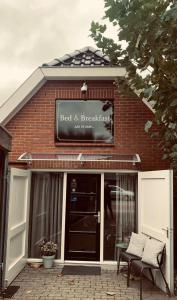 een rood bakstenen gebouw met een bord voor een bed and breakfast bij Bed & Breakfast "aan de banis" in Rijssen