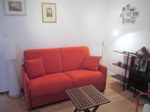 een woonkamer met een rode bank en een tafel bij LES PAILLETTES in Le Touquet-Paris-Plage