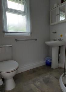 a white bathroom with a toilet and a sink at 89 Lower Lakeside - Glan Gwna Holiday Park in Caernarfon