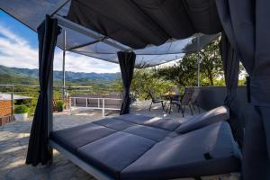 a bed on a patio with a table and chairs at Villa Vito - with heated pool, whirlpool, gym in Šarići