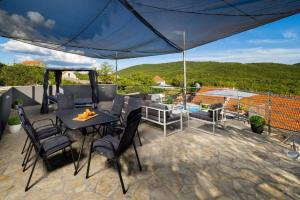 a patio with a table and chairs and a view at Villa Vito - with heated pool, whirlpool, gym in Šarići +50 photos