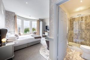 a bedroom with a bed and a tub and a toilet at Escape Boutique B&B in Llandudno