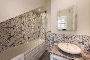 a bathroom with a sink and a mirror at Escape Boutique B&B in Llandudno