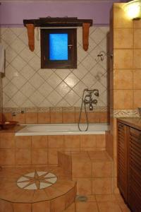 baño con bañera y ventana en ORFEAS HOYSE 1, en Patitiri