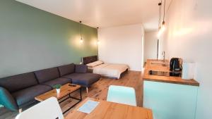 ein Wohnzimmer mit einem Sofa und einem Tisch in der Unterkunft K-Town - Apartments ViaBaltic Kaunas in Kaunas