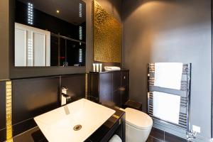 a bathroom with a white sink and a toilet at Escape Boutique B&B in Llandudno