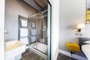 a bathroom with a glass shower and a sink at Escape Boutique B&B in Llandudno