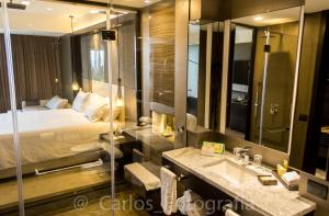 y baño con cama, lavabo y espejo. en Eb Hotel By Eurobuilding Quito Airport en Tababela