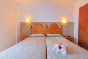 ein Schlafzimmer mit einem Bett, auf dem zwei Handtücher liegen in der Unterkunft Xon's Platja HA in Empuriabrava
